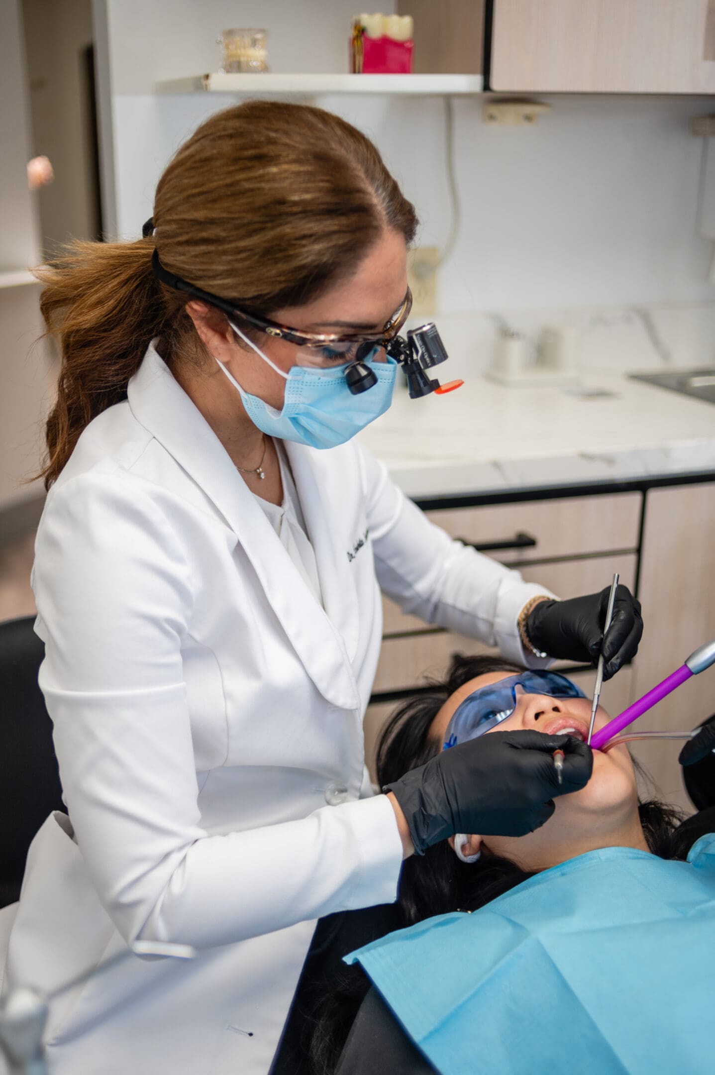 A dentist is working on the teeth of a patient.