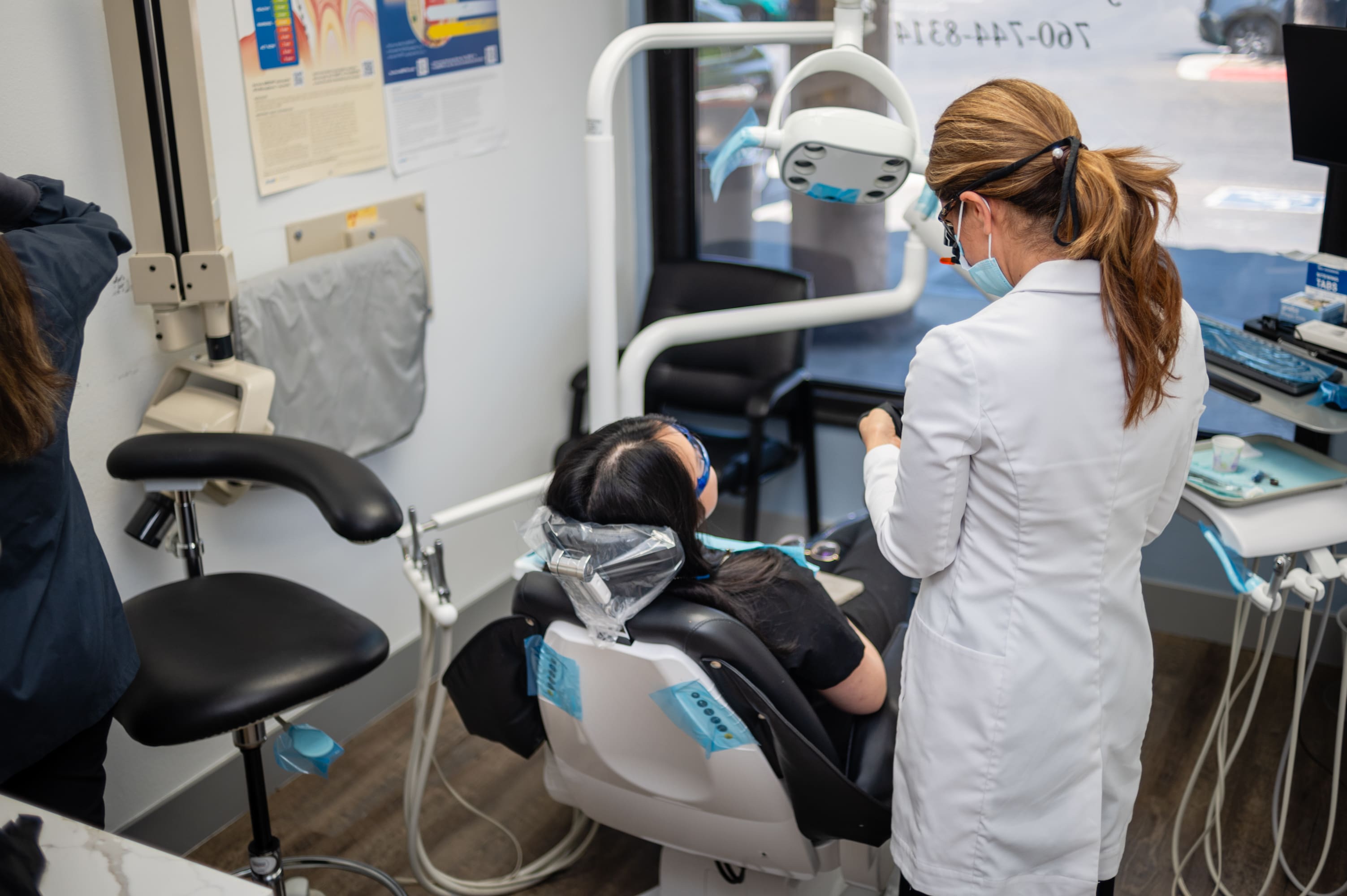 A dentist is working on the patient 's teeth.