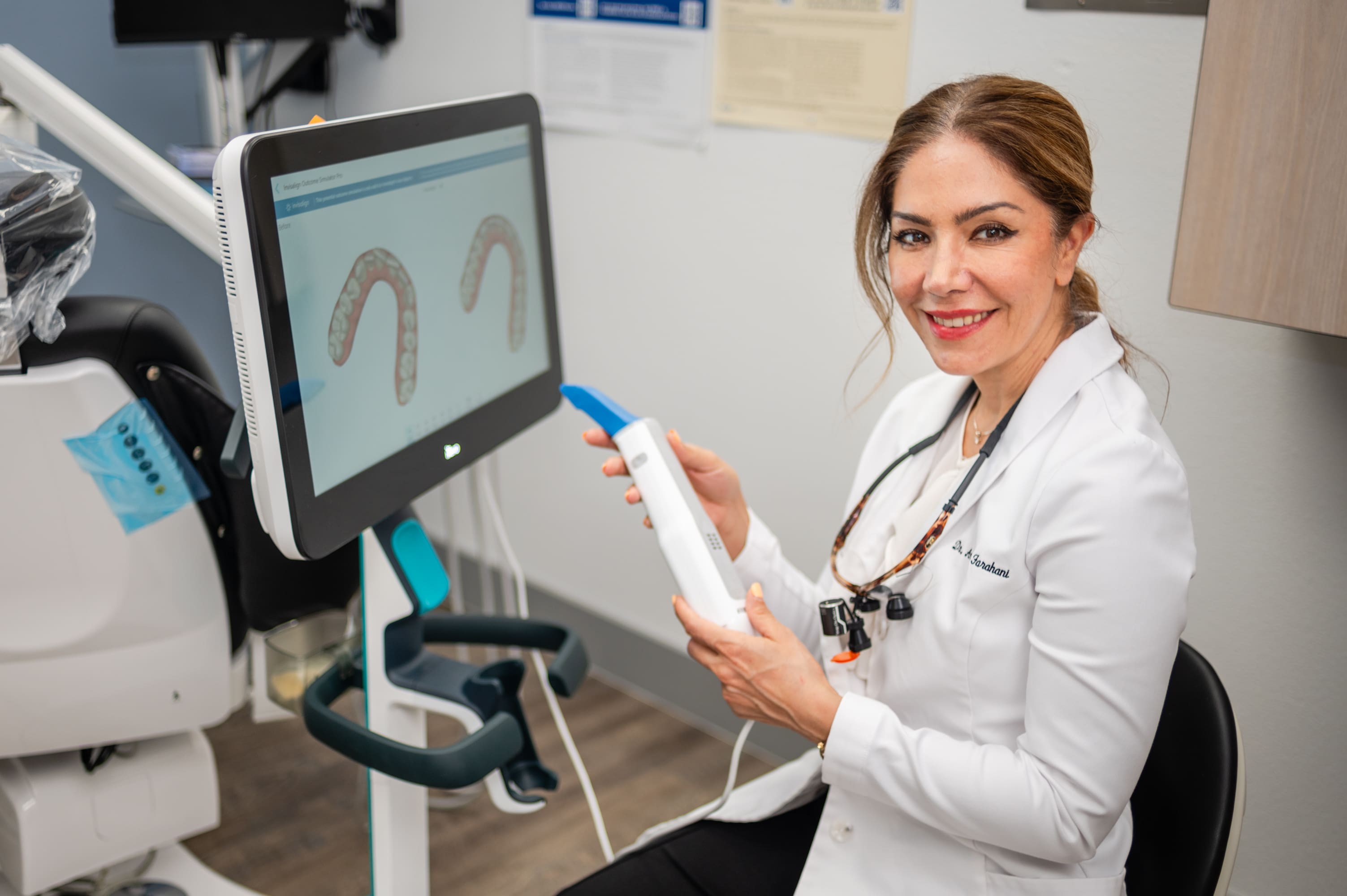 A woman holding a wii remote in front of a monitor.