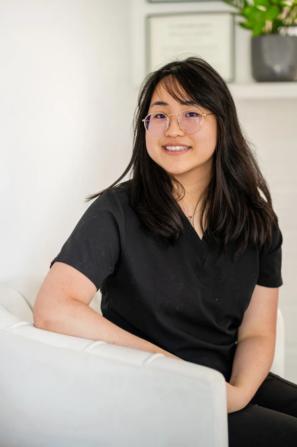 A woman sitting on top of a white couch.