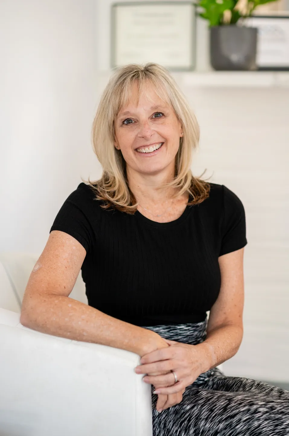 A woman sitting on top of a white couch.