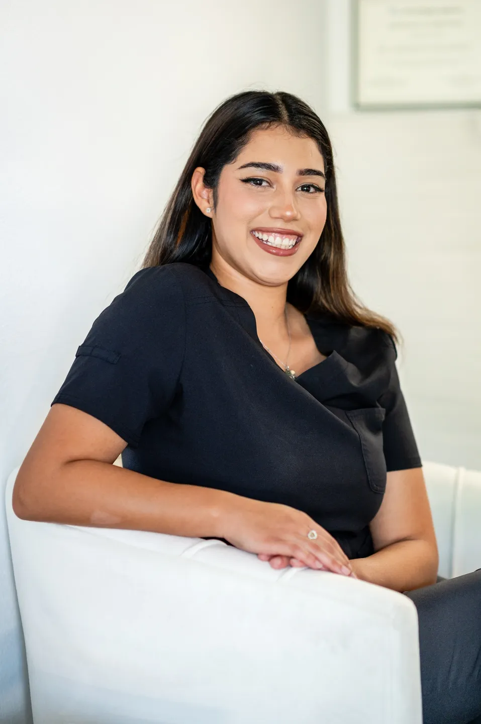 A woman sitting on top of a white couch.